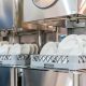 close up white plate on basket in automatic dishwasher machine for industrial